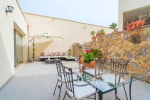 patio ze stołem i krzesłami oraz kamienną ścianą w obiekcie Casa Holganza w mieście Maria de la Salut