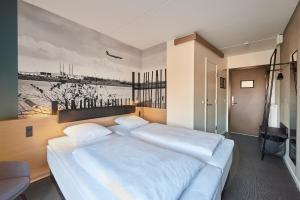 
a hotel room with a bed and a painting on the wall at Zleep Hotel Copenhagen Airport in Copenhagen
