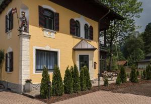 a yellow house with trees in front of it at Chalet Villa Ludwig in Schwangau