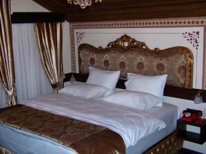 um quarto com uma cama grande e almofadas brancas em Edirne osmanlı evleri em Edirne