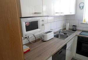 a kitchen counter with a sink and a microwave at Haus Harmonie in Bad Driburg