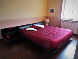 a red bed with two pillows on it in a bedroom at La Casa nel Borgo in Torre Orsina