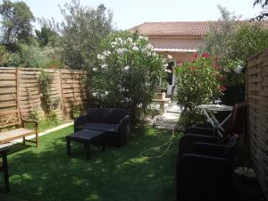 a garden with chairs and a bench on the grass at Residence Pezza Cardo in Porto-Vecchio