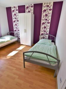 1 dormitorio con cama y pared púrpura en Work & Stay Sankt Augustin mit Dachterasse en Sankt Augustin