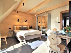 a bedroom with a large bed and a desk at VIP APARTAMENTY VILLA GÓRSKIE KLIMATY in Zakopane