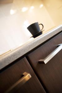 a black coffee cup sitting on a shelf at Melon Suites in Thessaloniki