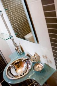 a bathroom with a blue sink and a mirror at Melon Suites in Thessaloniki