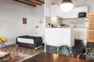 a kitchen and living room with a bed and a table at Brummell Apartments Eixample Derecha/Ballroom in Barcelona