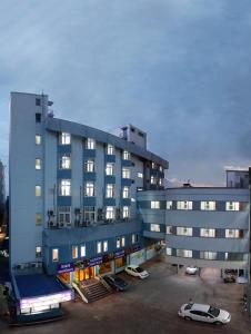 a large building with cars parked in a parking lot at Sri Aarvee Hotels in Coimbatore