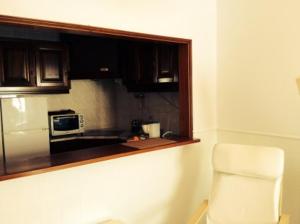 une cuisine avec une fenêtre, une chaise blanche et un four micro-ondes dans l'établissement Studio Martins, à Praia da Areia Branca