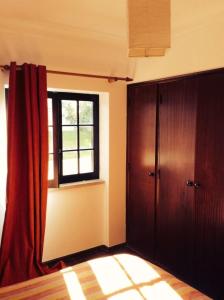 Zimmer mit einem Fenster und einem roten Vorhang in der Unterkunft Studio Martins in Praia da Areia Branca + 4 Fotos