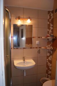 a bathroom with a sink and a mirror at Latarnik in Karwia