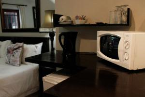 a microwave sitting on top of a table next to a bed at Amani Guest Lodge in Port Elizabeth
