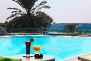 una piscina con una mesa con bebidas. en Holiday Inn Cairo Maadi, an IHG Hotel, en El Cairo