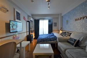 uma sala de estar com um sofá e uma cama em Apartment Zen Hotel em Mizuho