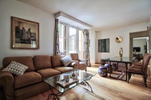 un soggiorno con divano e tavolo di LEGENDARY RUE DU TEMPLE 4/5 bedrooms a Parigi