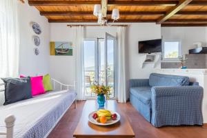 a living room with a couch and a table with a bowl of fruit at Villa Thea in Panormos Skopelos