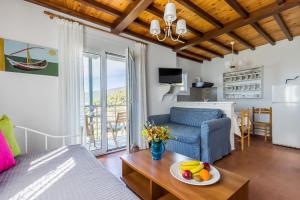a living room with a couch and a table with a bowl of fruit at Villa Thea in Panormos Skopelos