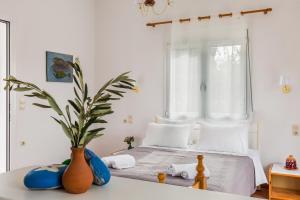 a bedroom with a bed with a vase on a table at Villa Thea in Panormos Skopelos