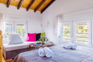 two beds in a room with two windows at Villa Thea in Panormos Skopelos