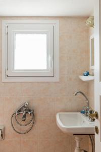 a bathroom with a sink and a window at Villa Thea in Panormos Skopelos +23 photos