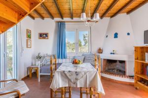 a dining room with a table and a fireplace at Villa Thea in Panormos Skopelos