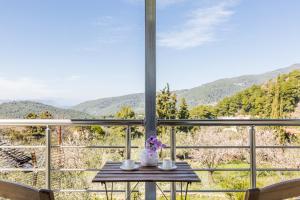 a table with flowers on a balcony with a view at Villa Thea in Panormos Skopelos