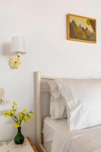 a bedroom with a white bed with a vase of flowers at Villa Thea in Panormos Skopelos