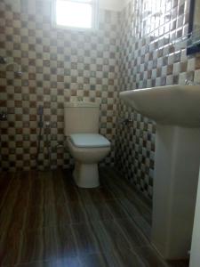 a bathroom with a toilet and a sink at Nethmi Rooms in Negombo