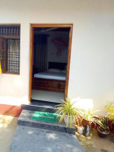 a bedroom with a bed in a room with plants at Nethmi Rooms in Negombo