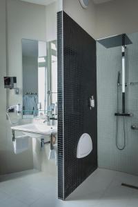 La salle de bains est pourvue d'un lavabo et d'une douche. dans l'établissement Château D'Apigné Rennes, à Le Rheu