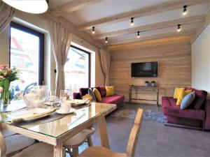 a living room with a dining table and a tv at VIP APARTAMENTY VILLA GÓRSKIE KLIMATY in Zakopane