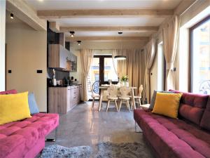 a living room with a couch and a dining room at VIP APARTAMENTY VILLA GÓRSKIE KLIMATY in Zakopane