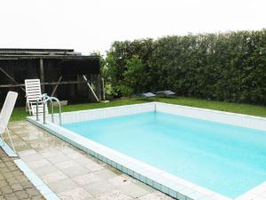 a large swimming pool with a chair and a table at Mit Pool bei Grevesmühlen in Schönhof