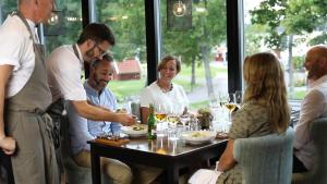 a group of people sitting around a table at a restaurant at Katrinelund Gästgiveri & Sjökrog in Stora Mellösa