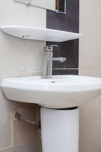 a white sink in a bathroom with a mirror at Résidences ASKÉ in Abomey-Calavi +23 photos