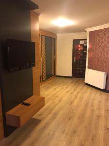 a living room with a flat screen tv and a wooden floor at Ulasan Hotel Caravan Camping in Ankara