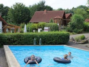 two children playing in an outdoor swimming pool at Holiday Home in Germany with Garden Terrace in Bredenborn +24 photos