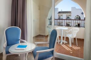 Habitación con mesa, sillas y balcón. en Mac Puerto Marina Benalmádena en Benalmádena