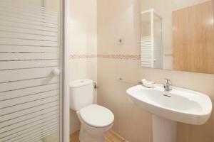 a white bathroom with a toilet and a sink at Musika Plaza in Zarautz