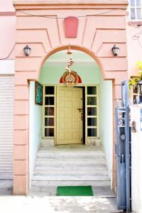 een ingang naar een roze gebouw met een gele deur bij Swagat homestay in Kathmandu