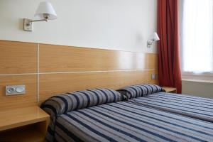 um quarto com uma cama com duas almofadas em Musika Plaza em Zarautz