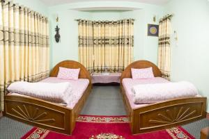 2 letti in una camera con tappeto rosso di Swagat homestay a Kathmandu