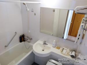 a bathroom with a sink and a tub and a mirror at Hiroshima Airport Hotel in Mihara +24 photos