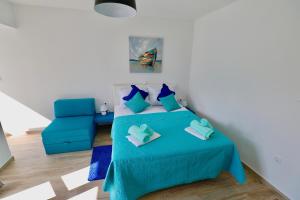 1 dormitorio con 1 cama azul y 1 silla azul en Meridiens, en Dubrovnik