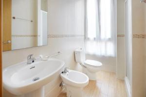 a white bathroom with a sink and a toilet at Musika Plaza in Zarautz