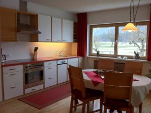 una cucina con tavolo e una cucina con finestra di Apartment Bachmann a Bludenz