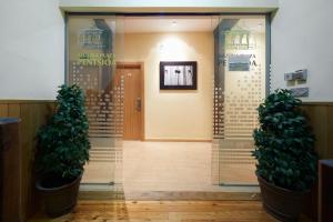 a lobby with two potted trees in front of a door at Musika Plaza in Zarautz