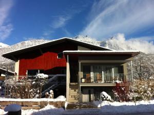 una casa nella neve di fronte a una montagna di Apartment Bachmann a Bludenz