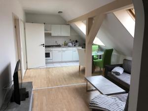 Una sala de estar con un sofá y una cocina. en Kuschelige Dachgeschosswohnung am Clarapark, en Leipzig